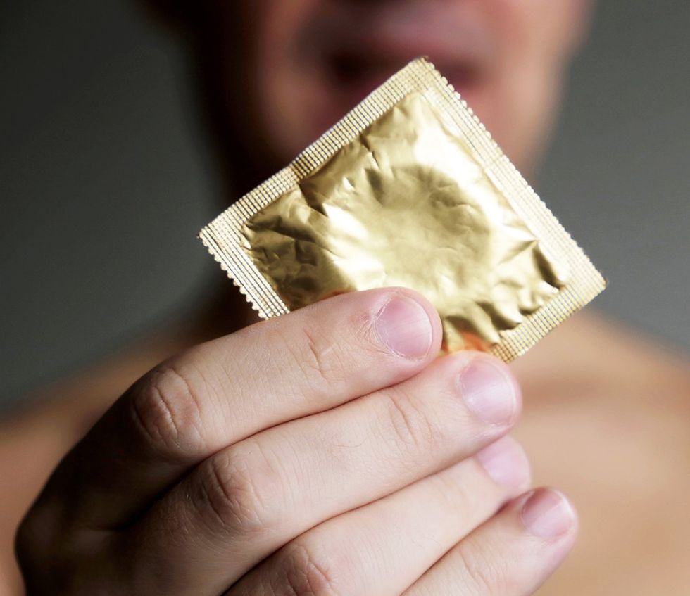 close up gold foil condom fingers