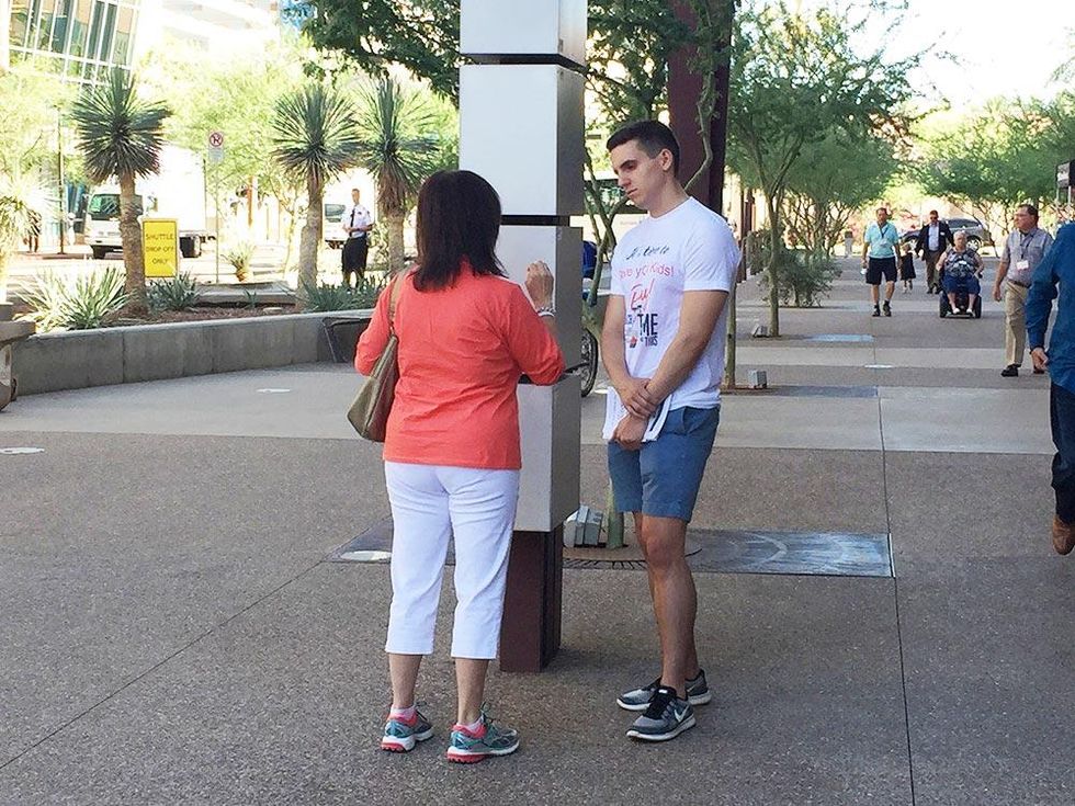 Coalition members speak with attendees of the Southern Baptist Convention meeting in front of the Phoenix Convention Center.