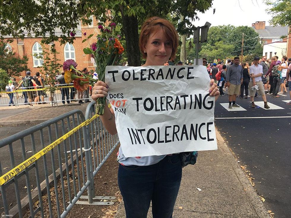 Colleen Cook, 26, holds a sign as hundreds of people are facing off in Charlottesville, Va., ahead of a white nationalist rally planned in the Virginia city's downtown.