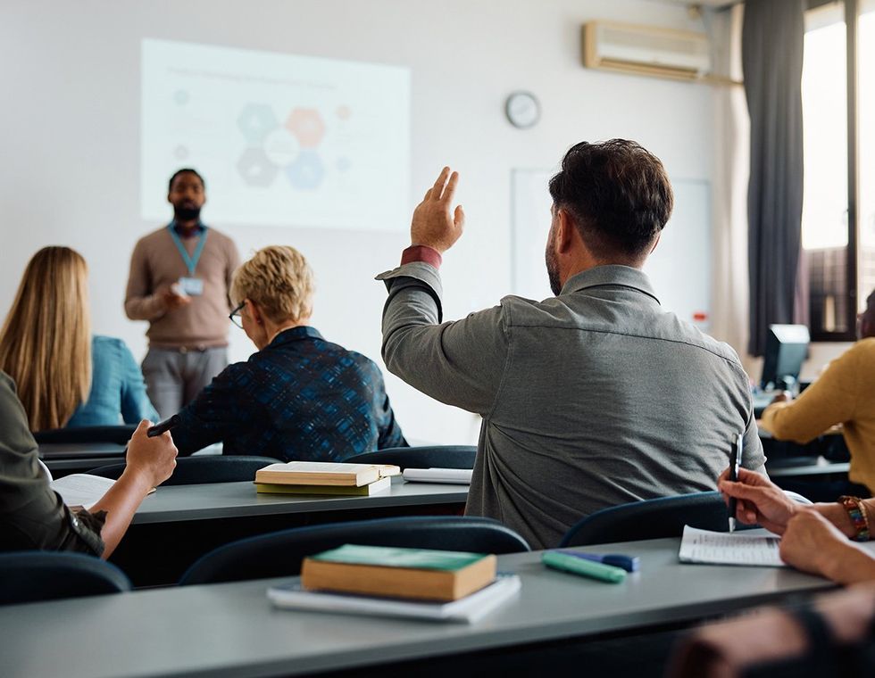 college student raising his hand in class