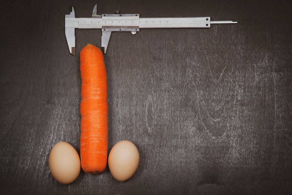 Concept of increasing male penis and operation, increase male organ, carrot with two eggs and a caliper on a black background
