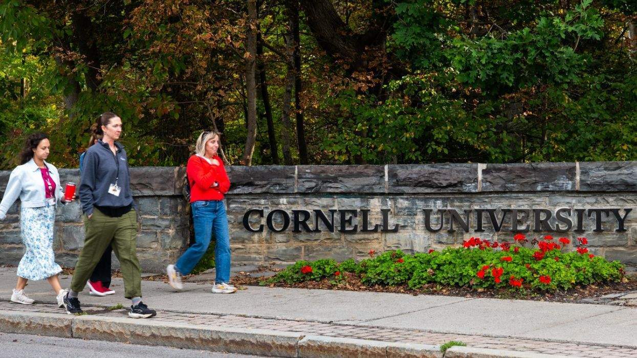 cornell university sign with people walking past it