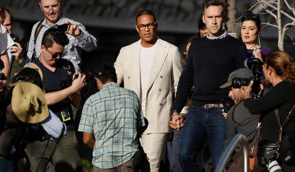Don Lemon and husband Tim Malone surrounded by journalists as they leave a court in los angeles holding hands.