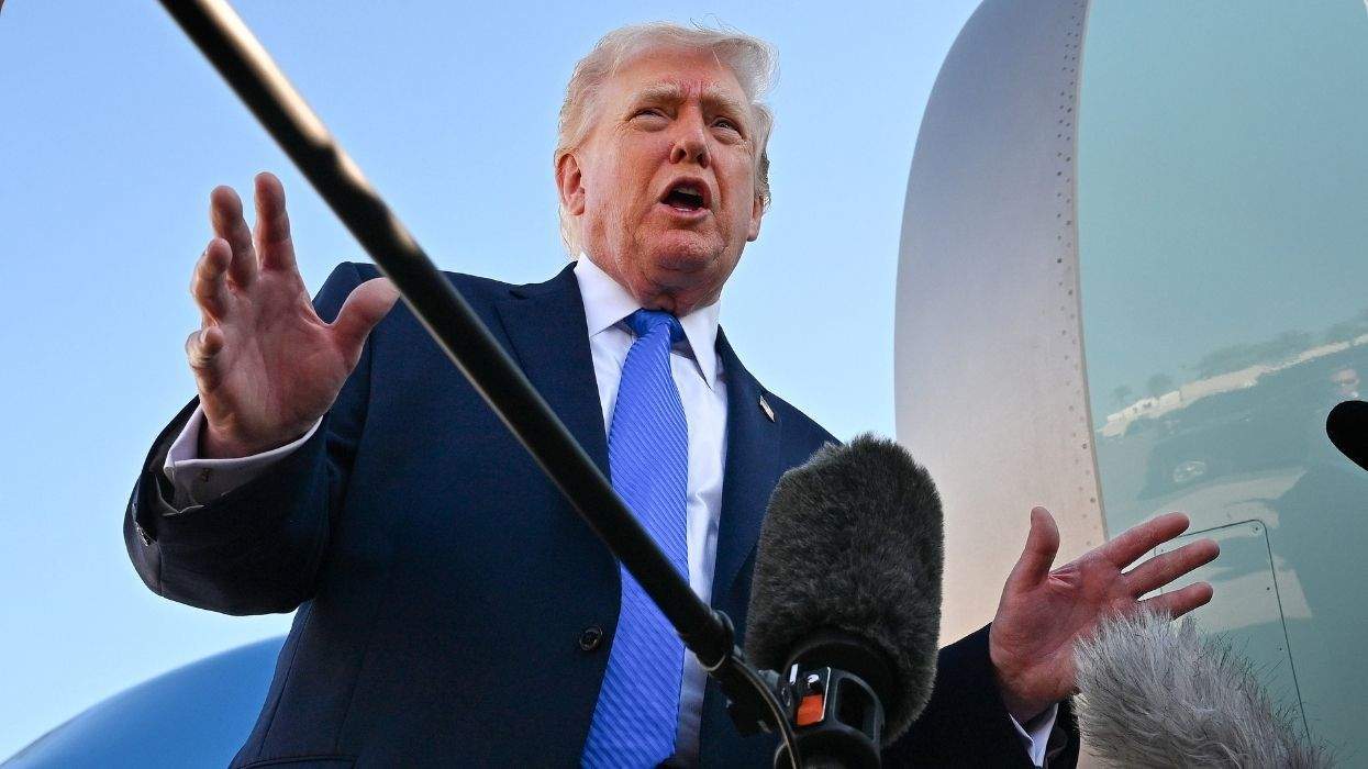 donald trump speaking to reporters with microphones in front of air force one