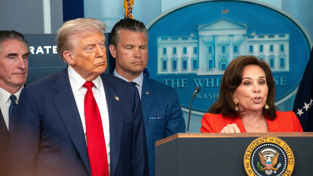 Donald Trump stands beside Jeanine Pirro while she speaks at a podium