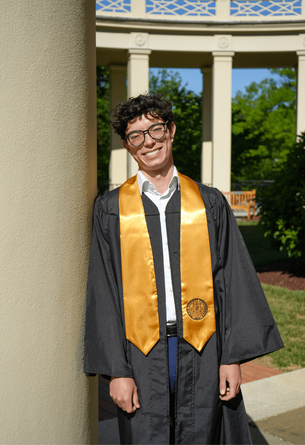 Eli Leadham poses in graduation regalia on the Wake Forest University campus