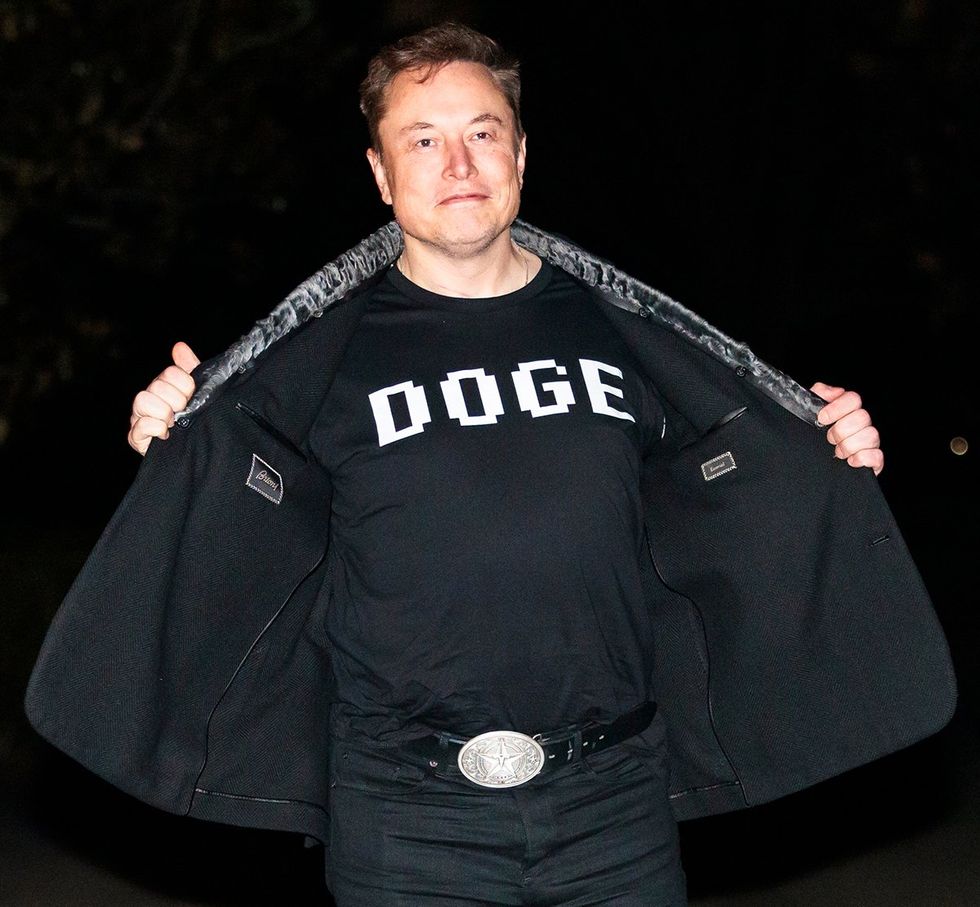 Elon Musk reveals a DOGE t-shirt and a Tesla belt buckle before entering the White House