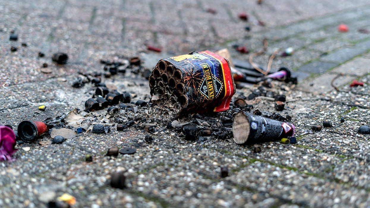 empty cardboard firework package and shells littered on sidewalk