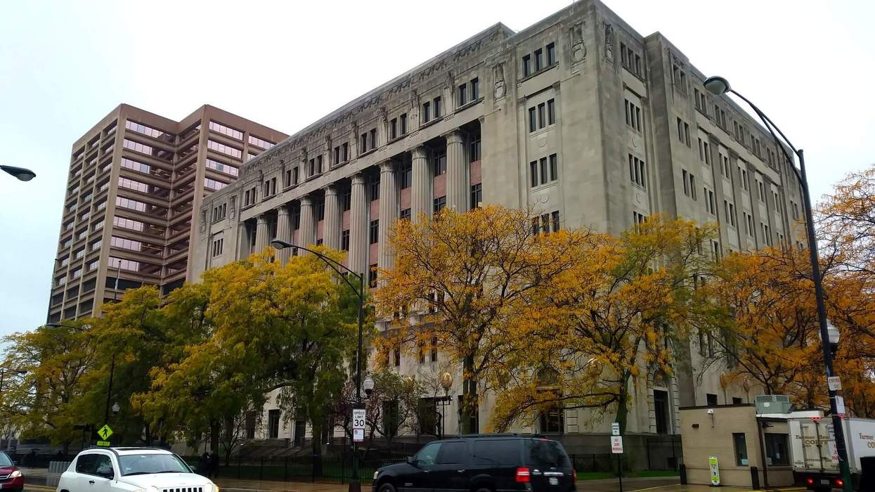 Fall foliage surrounds a courthouse building on a city street.