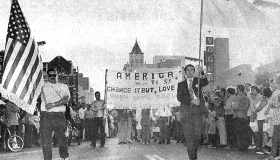Flags, banners, and a large crowd on Hollywood Boulevard.