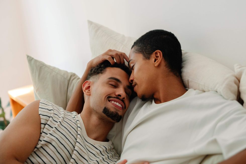 Gay men cuddling in bed