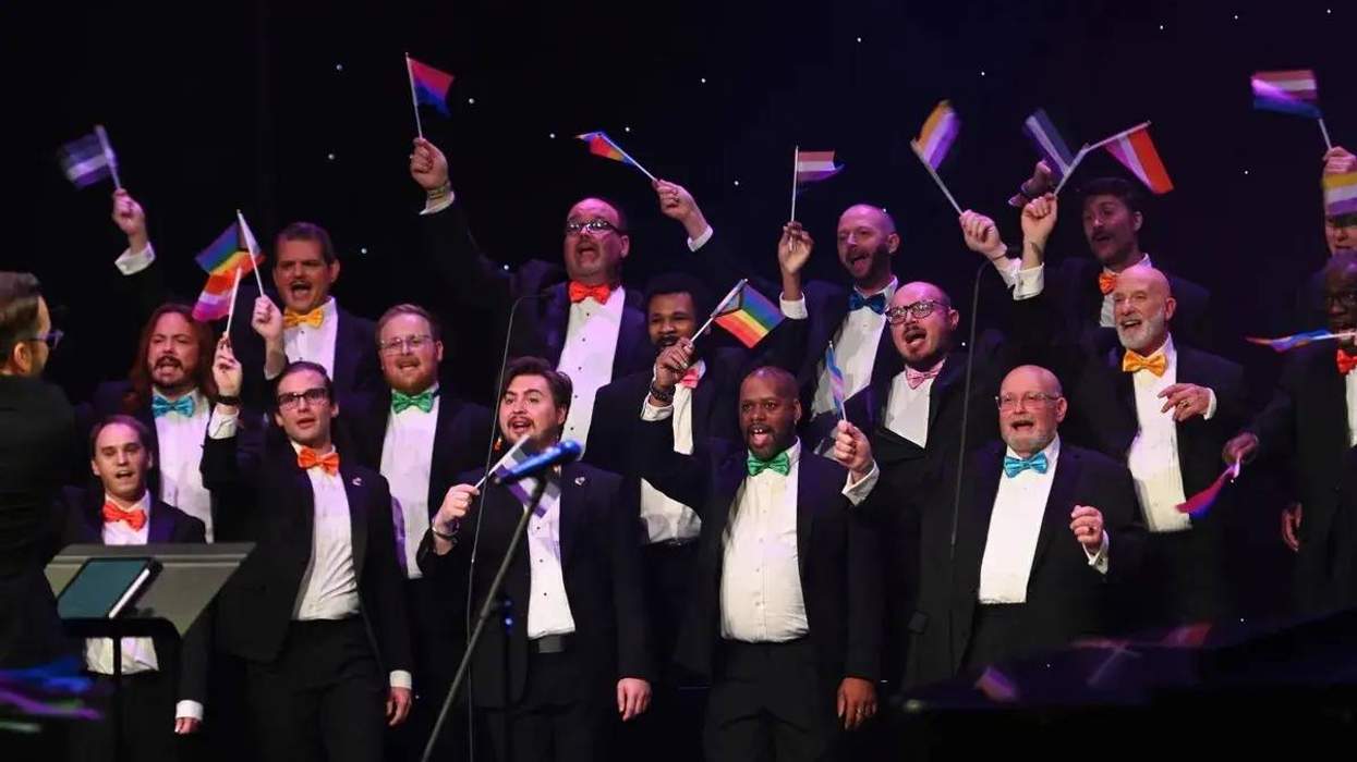 Gay men singing and waving Pride flags