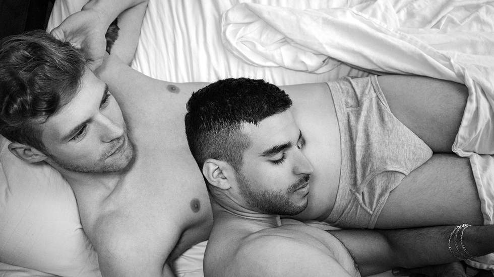 gay men snuggle in bed wearing underwear