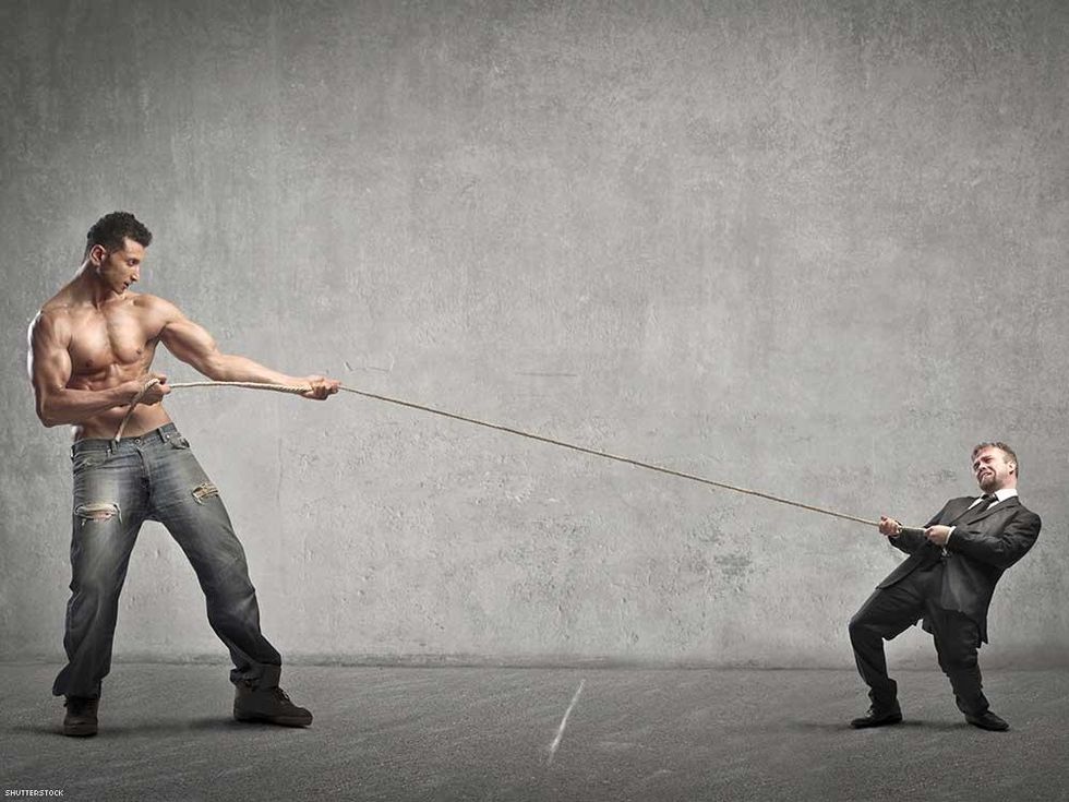 giant muscle man tug of war with small business man