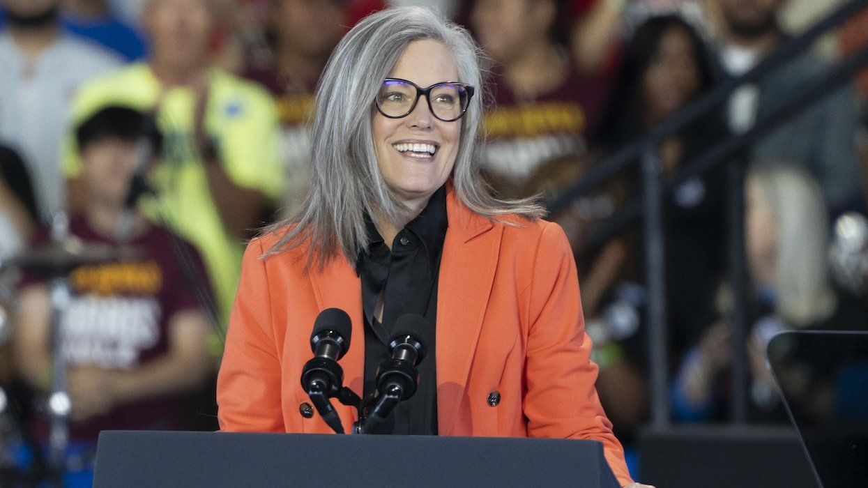 Gov. Katie Hobbs speaking at a rally with a crowd behind her.
