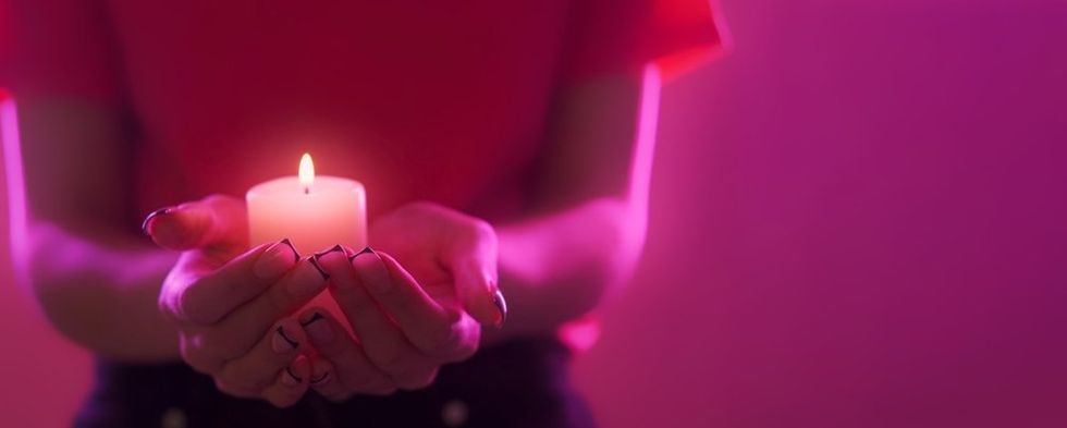 Hands holding candle pink