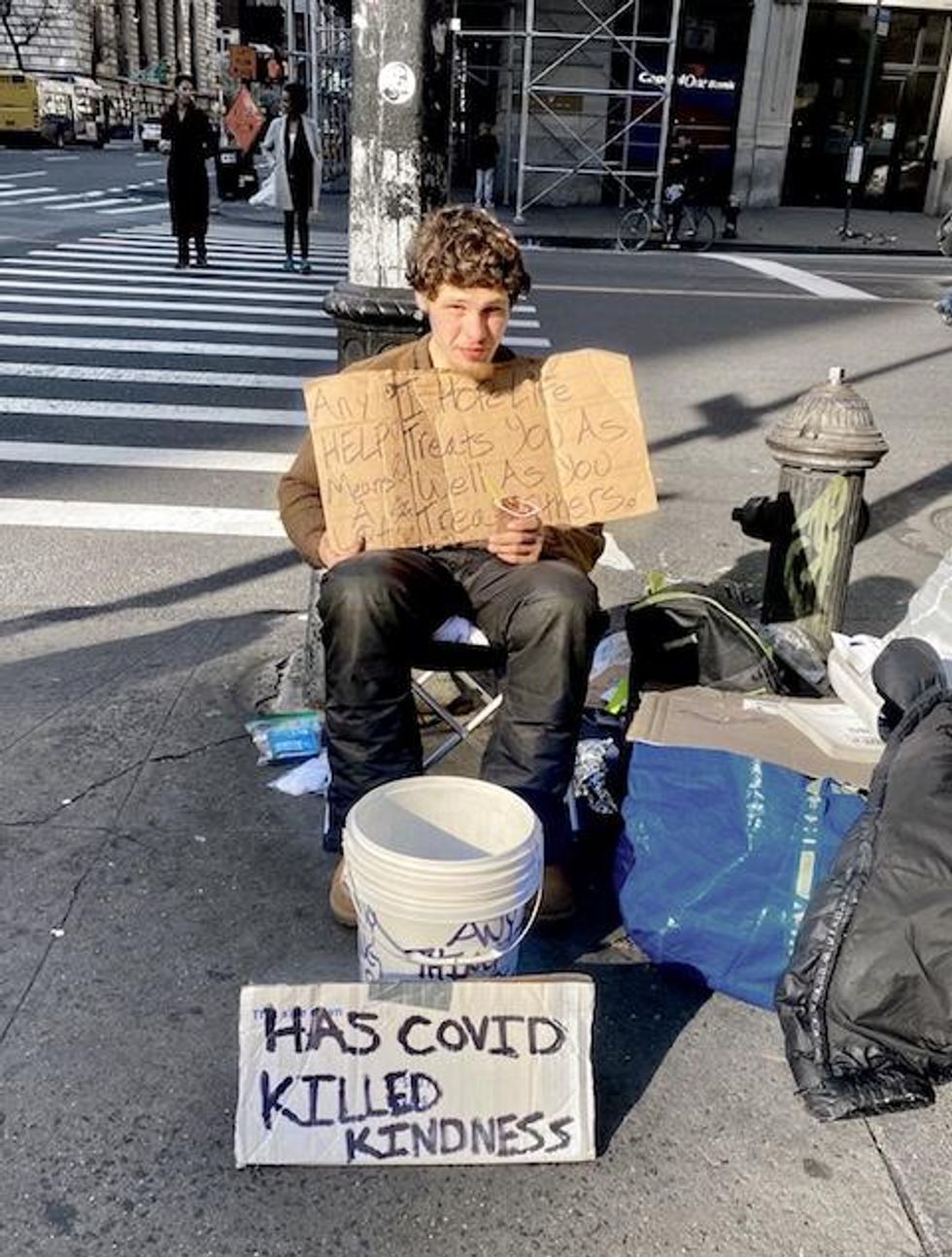 homeless person living in New York City looks at the camera