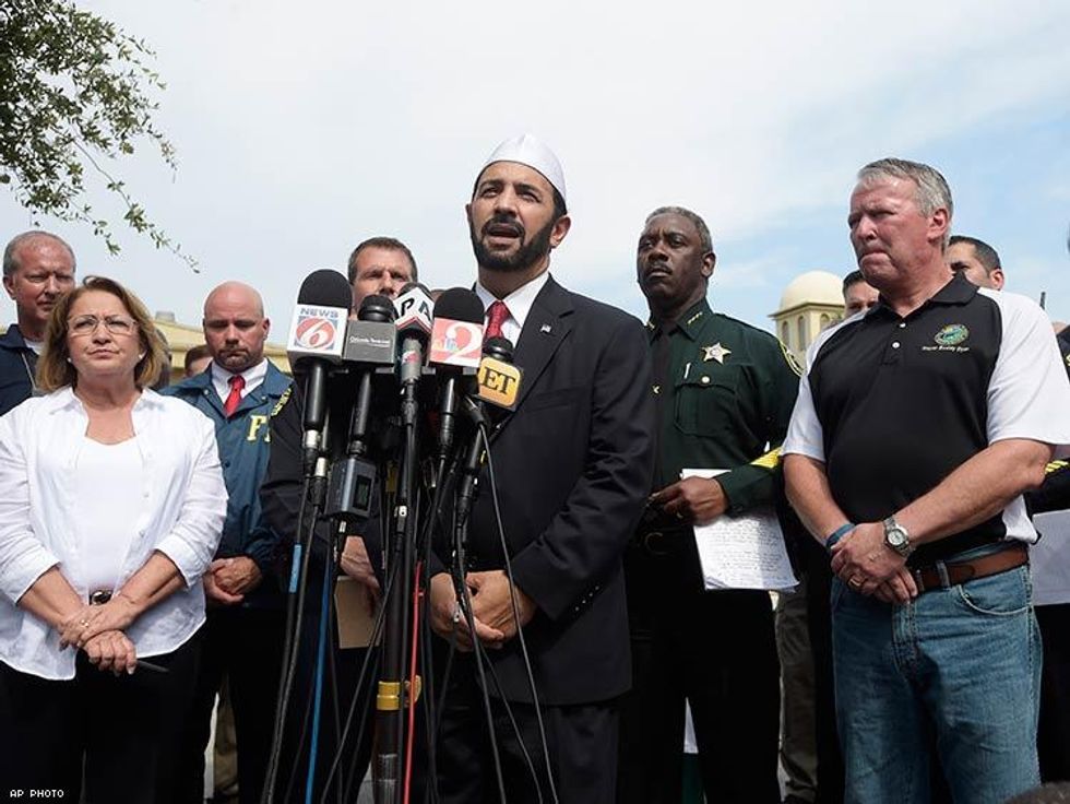 Imam Muhammad Musri, center, president of the Islamic Society of Central Florida, addresses reporters while flanked by members of law enforcement