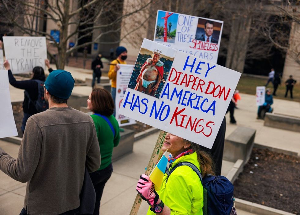 Indianapolis Indiana protester holds a sign reading Hey Diaper Don America has no kings