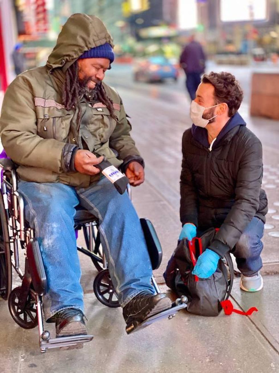 Jayson helping someone who is living on the street in New York City