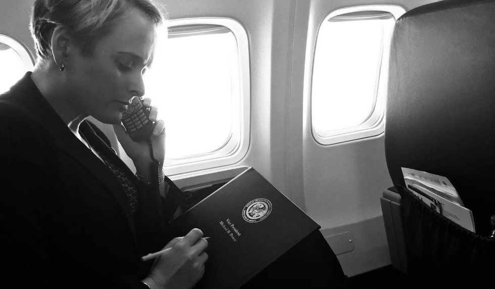 julia curlee sits on air force two on the phone holding a vice president mike pence folder