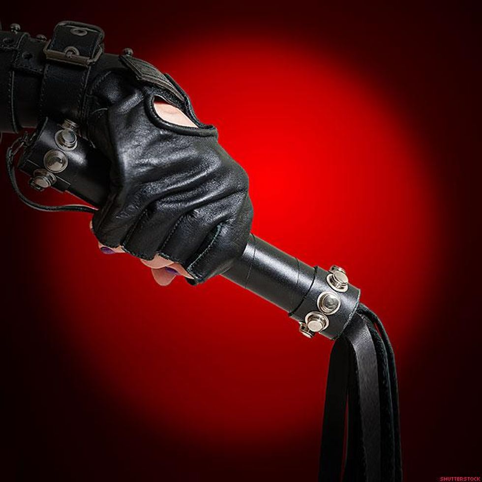 leather gloved hand holding a leather baton