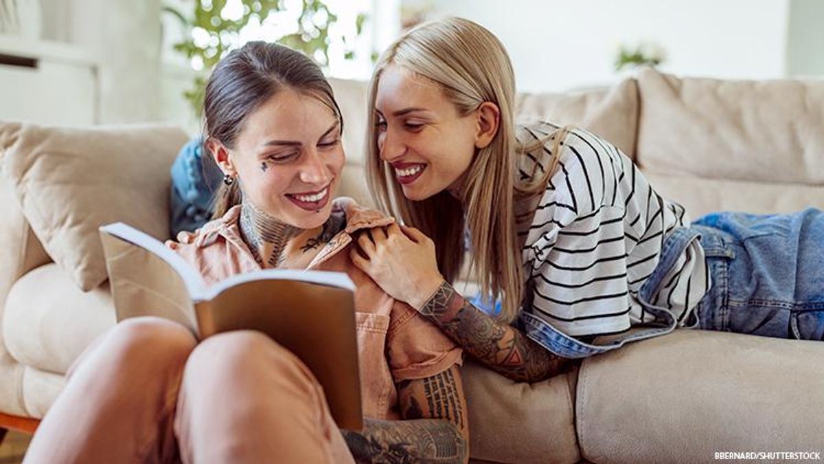 Lesbian same-sex couple reading happily
