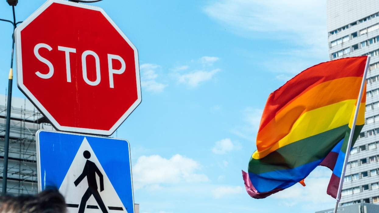 LGBTQ+ Pride flag next to stop sign