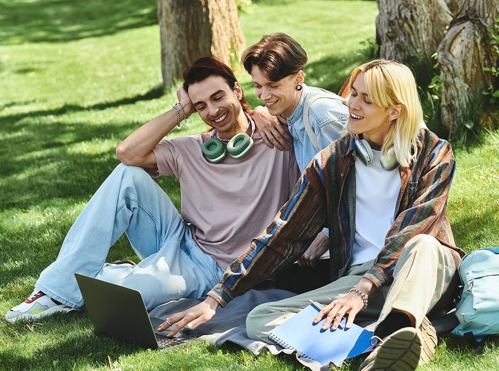 LGBTQIA youth using laptop outside