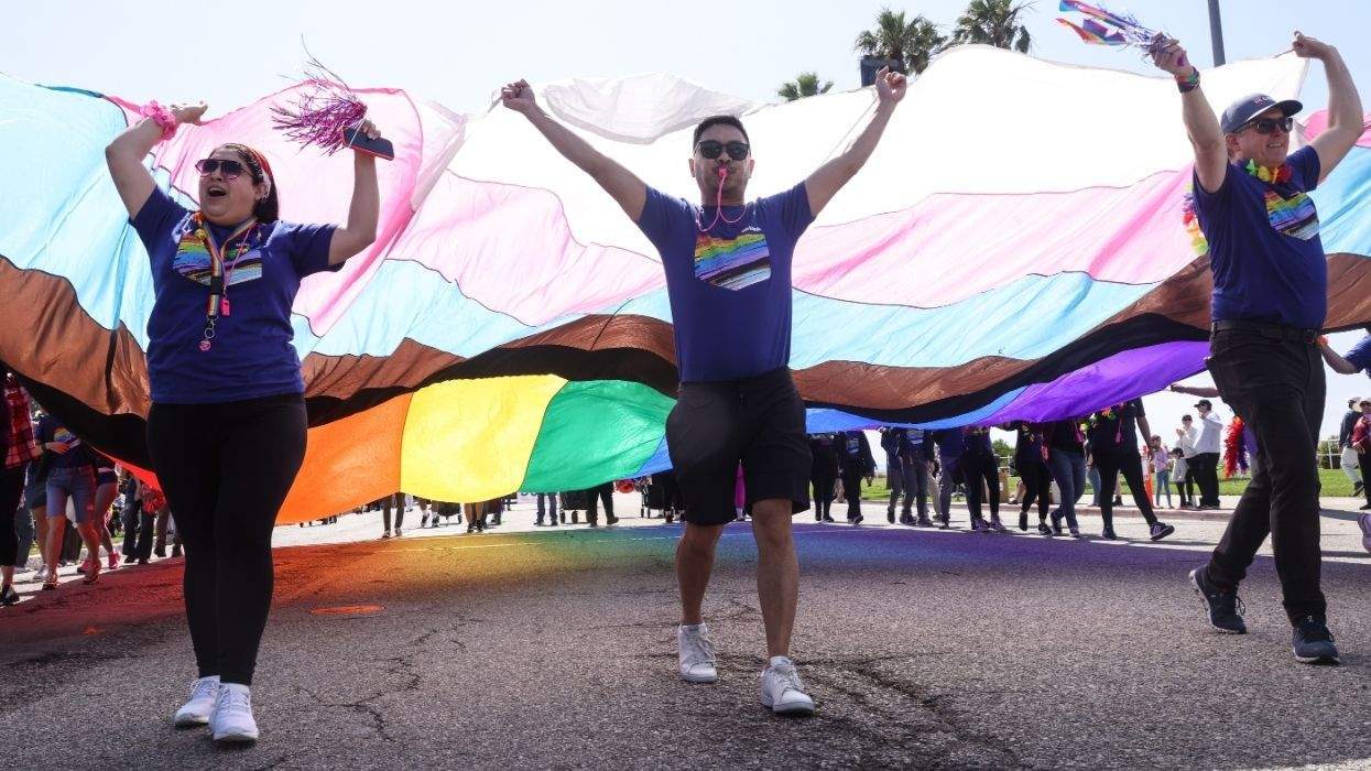 long beach pride participants with a giant lgbtq pride flag.