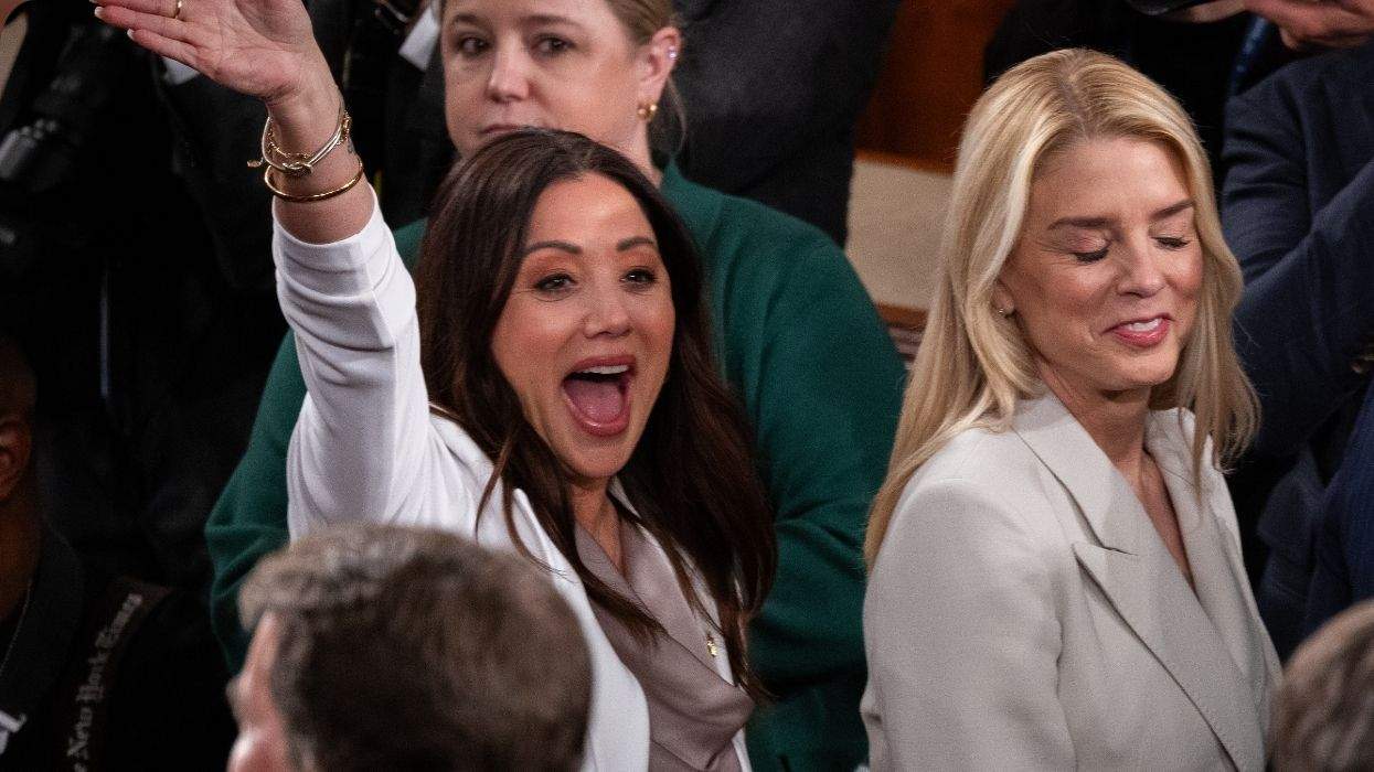 lori chavez-deremer waving as she walks behind pam bondi