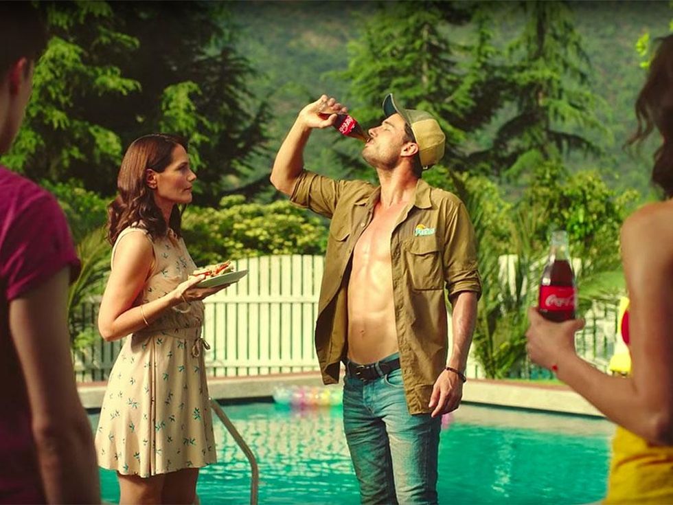 man drinking soda near the pool