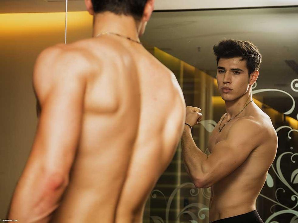 man flexing muscle in mirror