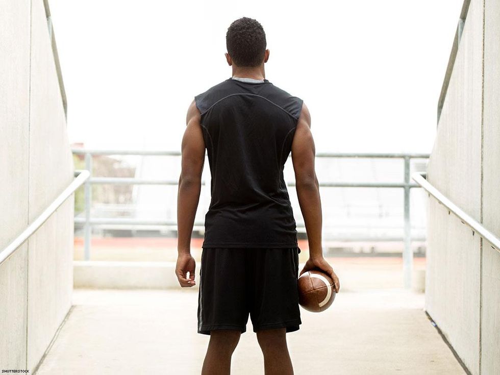 man from behind holding football