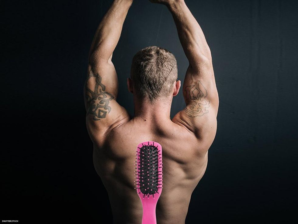 man from behind with arms up and a hairbrush in the forground