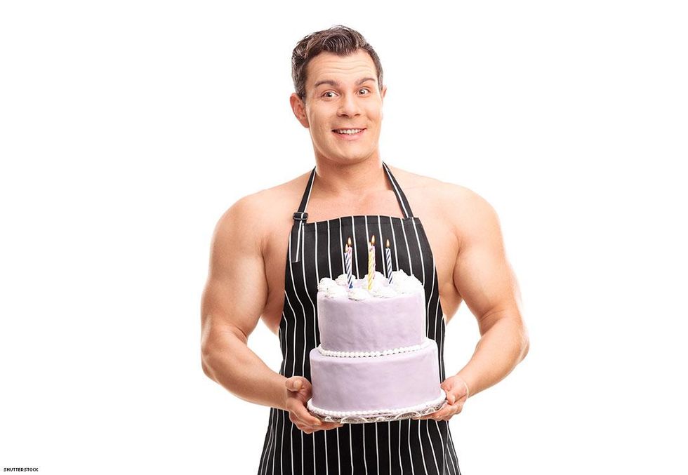 man in apron with birthday cake