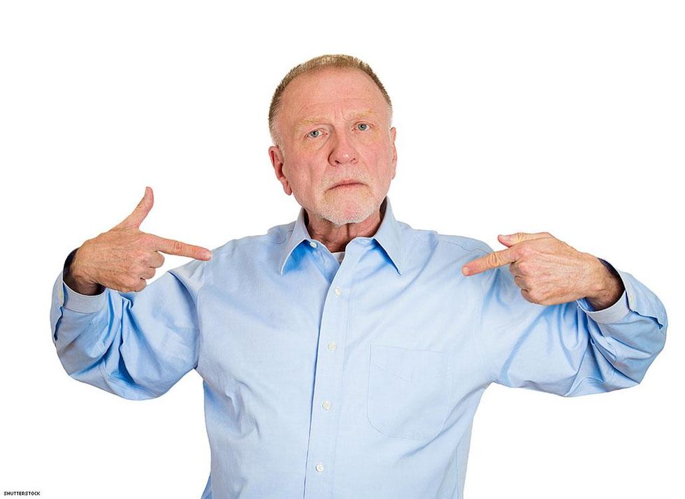 man in blue shirt pointing at himself