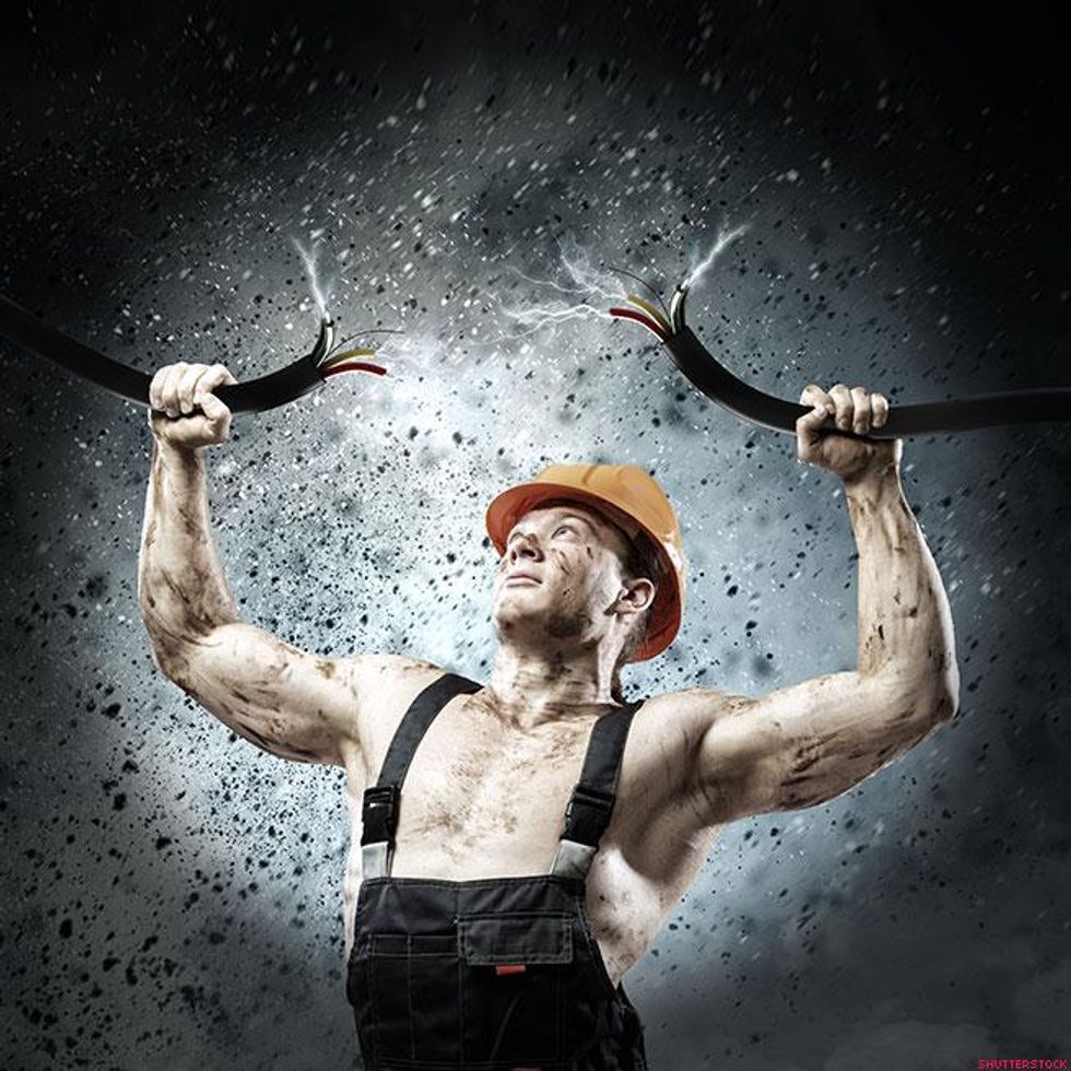 man in overalls holing a live electrical wire