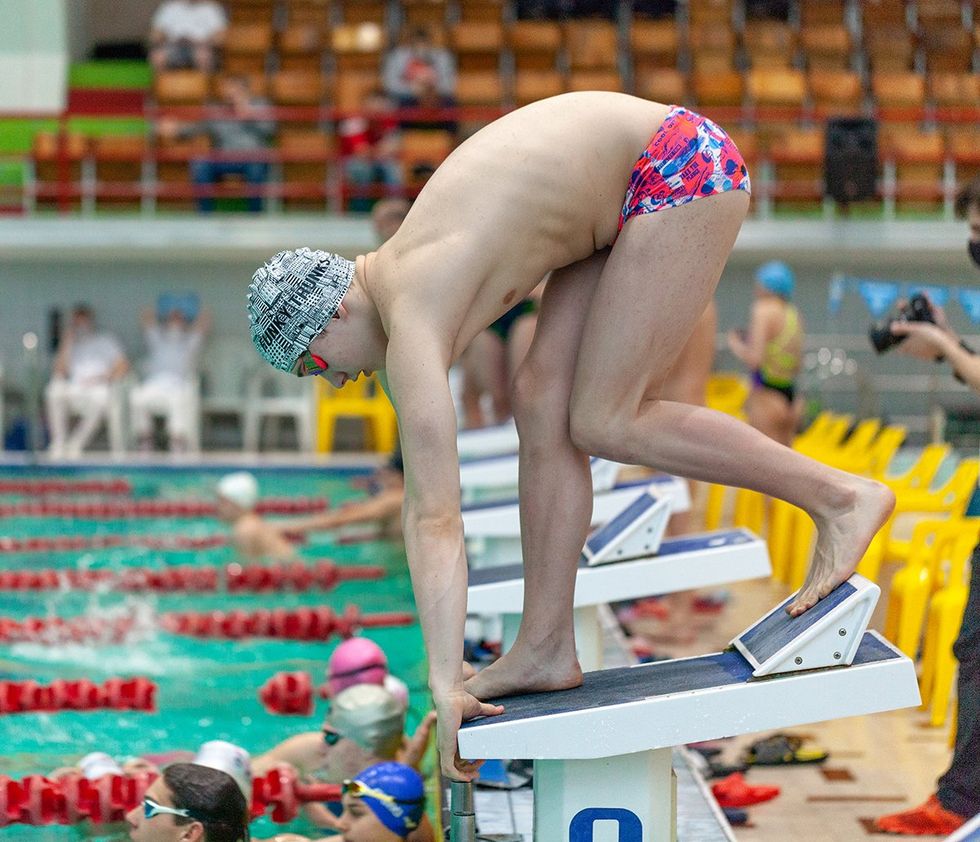 man on starting block at swim meet
