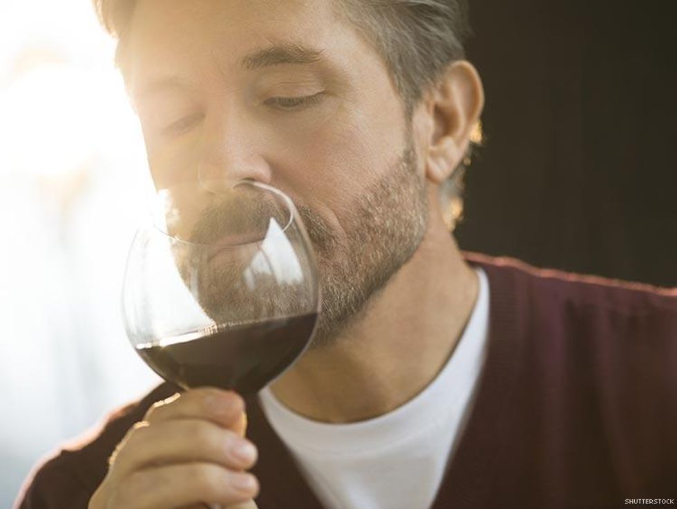 man selling glass of red wine