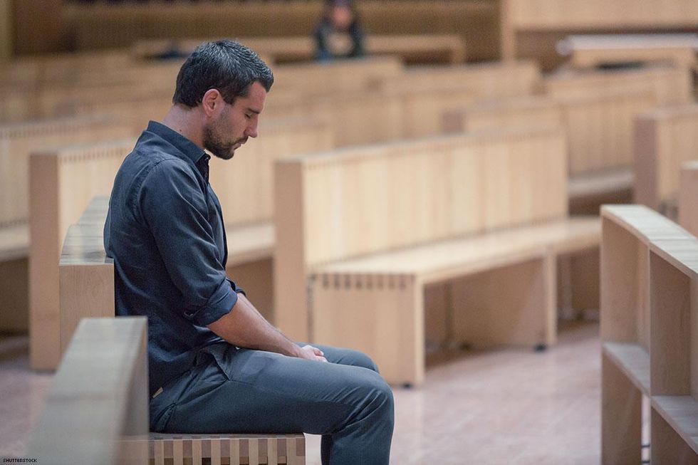 man sitting on wooden church bench