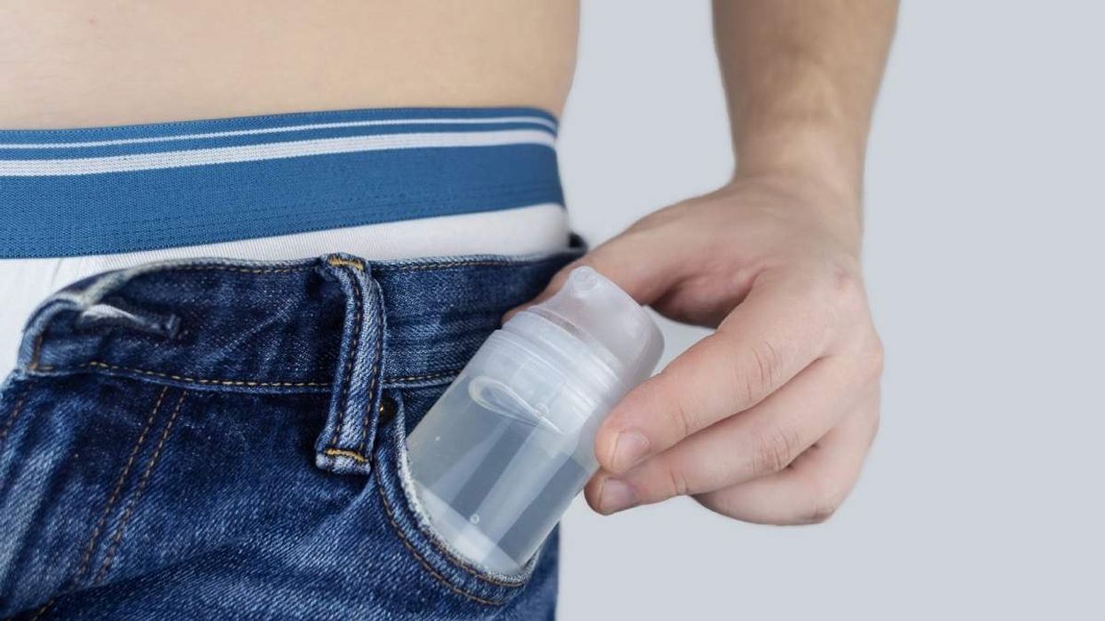 Man taking out a bottle of intimate lubricant from his pocket