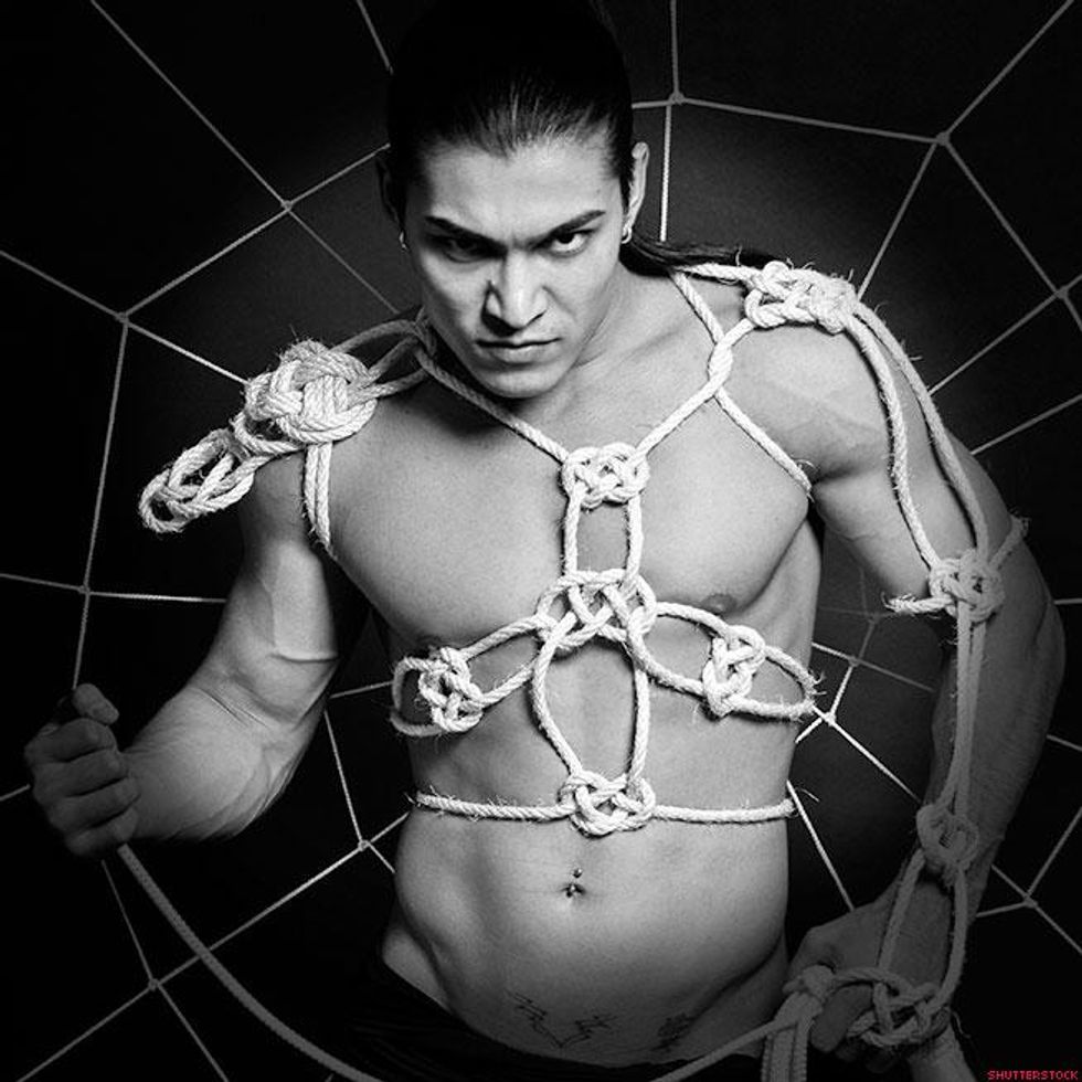 man trapped in spiderweb of ropes
