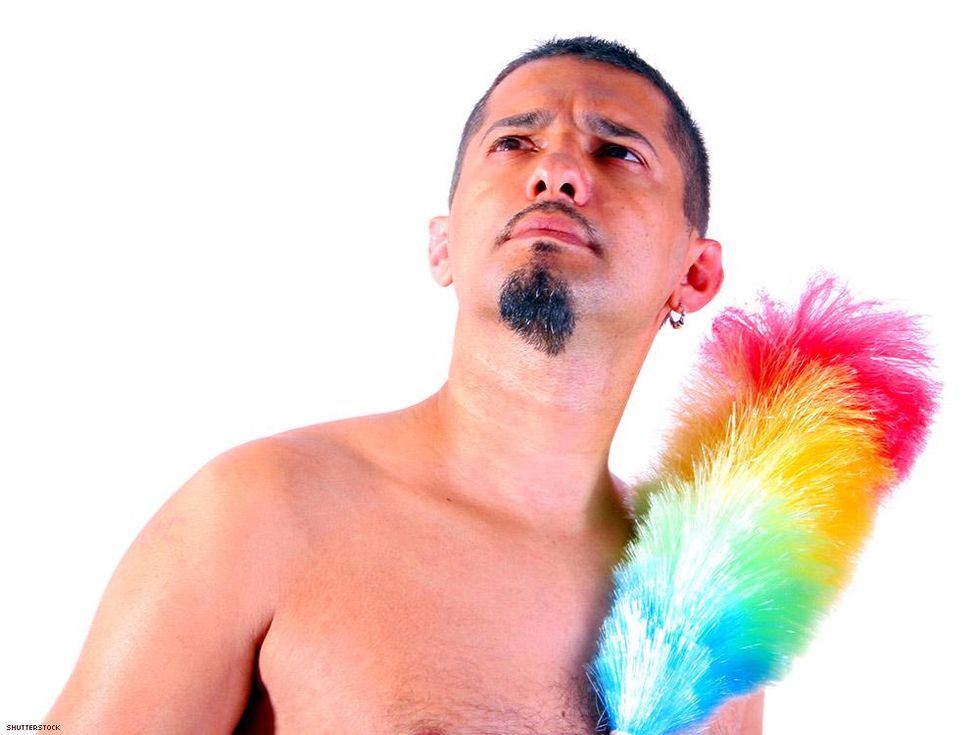 man with a goatee holding a rainbow feather duster