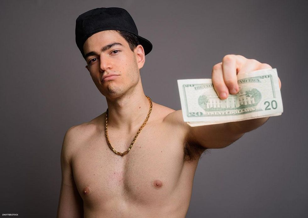 man with baseball cap holding money