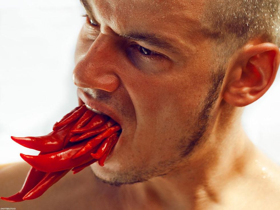 man with chili peppers in his mouth