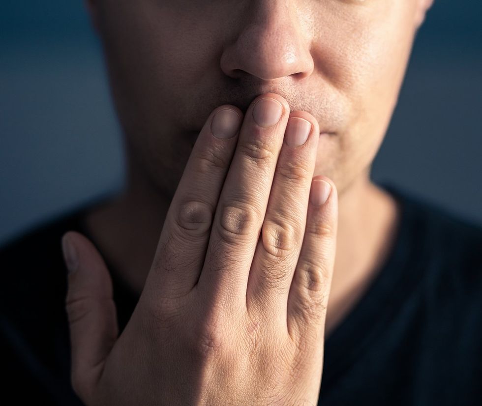 man with fingers over lips to keep a secret