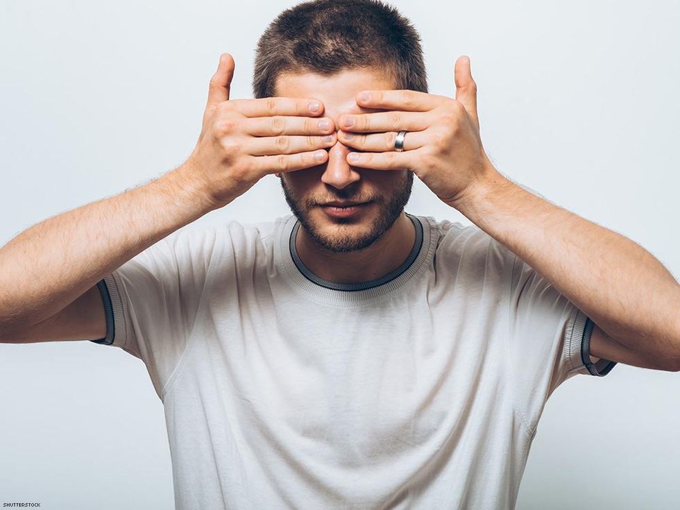man with hands covering eyes