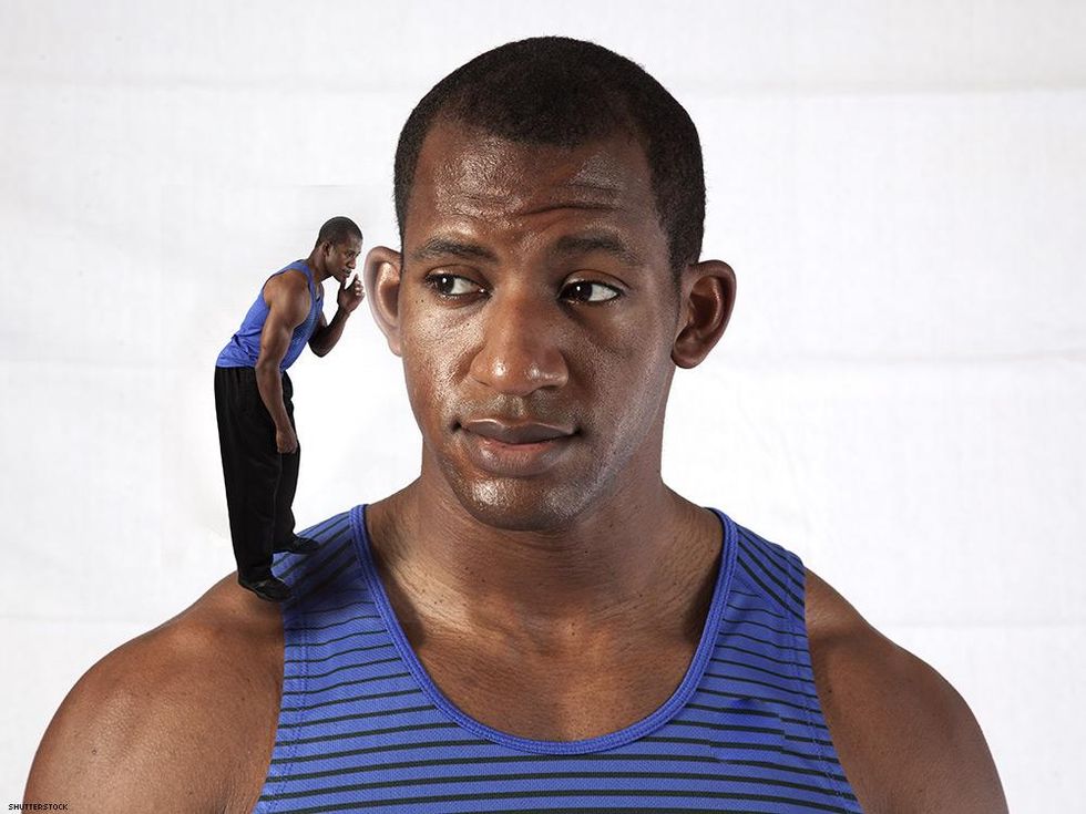 man with smaller man whispering in his ear