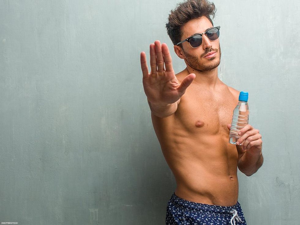 man with sunglasses and water bottle holing up hand to say stop